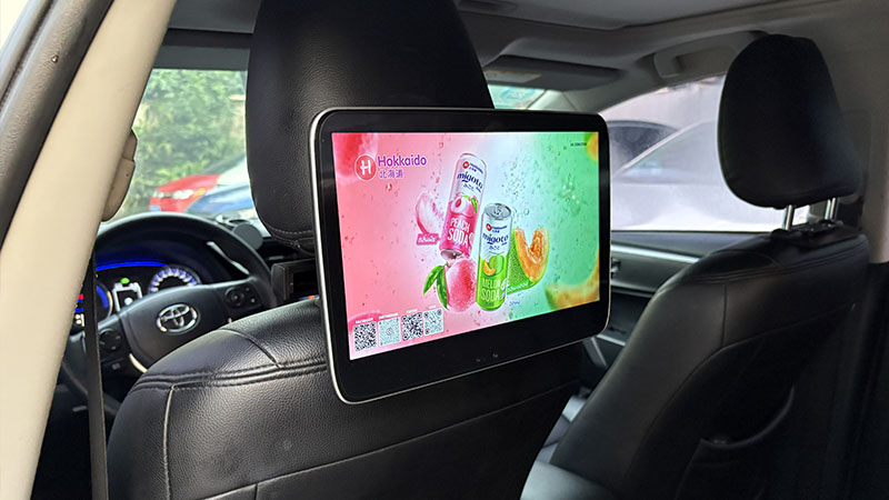 11.6 inch Android taxi headrest display installed on a taxi seat for passenger advertising.